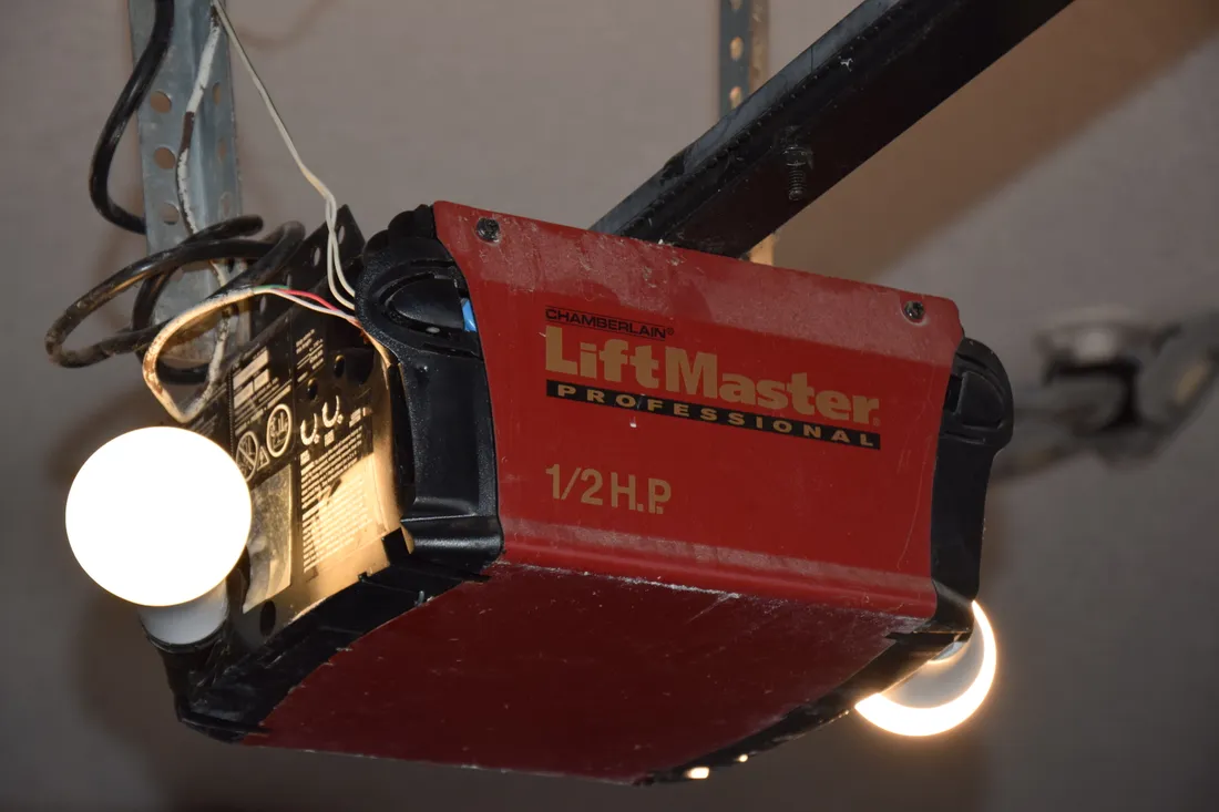 A ceiling-mounted LiftMaster opener with its light switched on