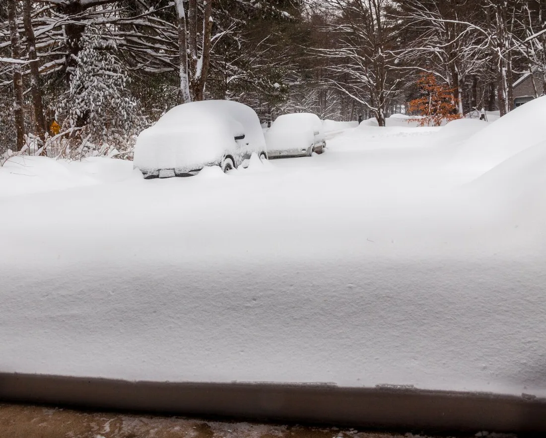 Deep snow outside an open garage, viewed from the garage threshold