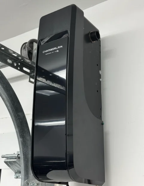 Side view of a Chamberlain wall-mount opener beside the curved garage door track