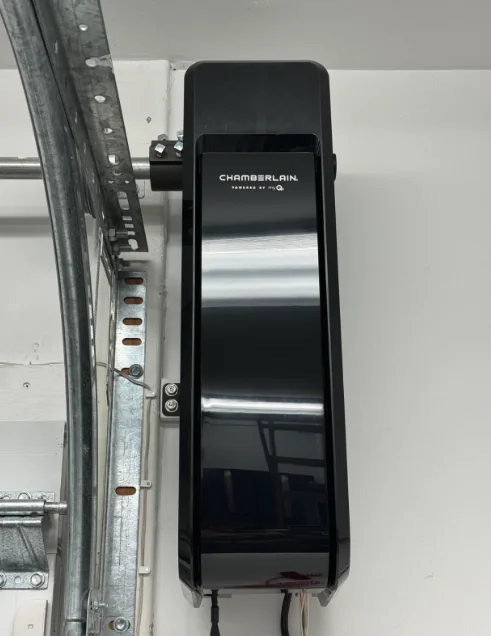 Chamberlain side-mount opener mounted on a white garage wall beside the door