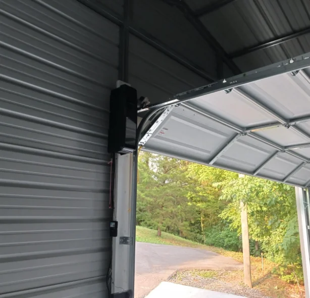 Chamberlain side-mount opener in a metal-sided garage with the door open to the driveway